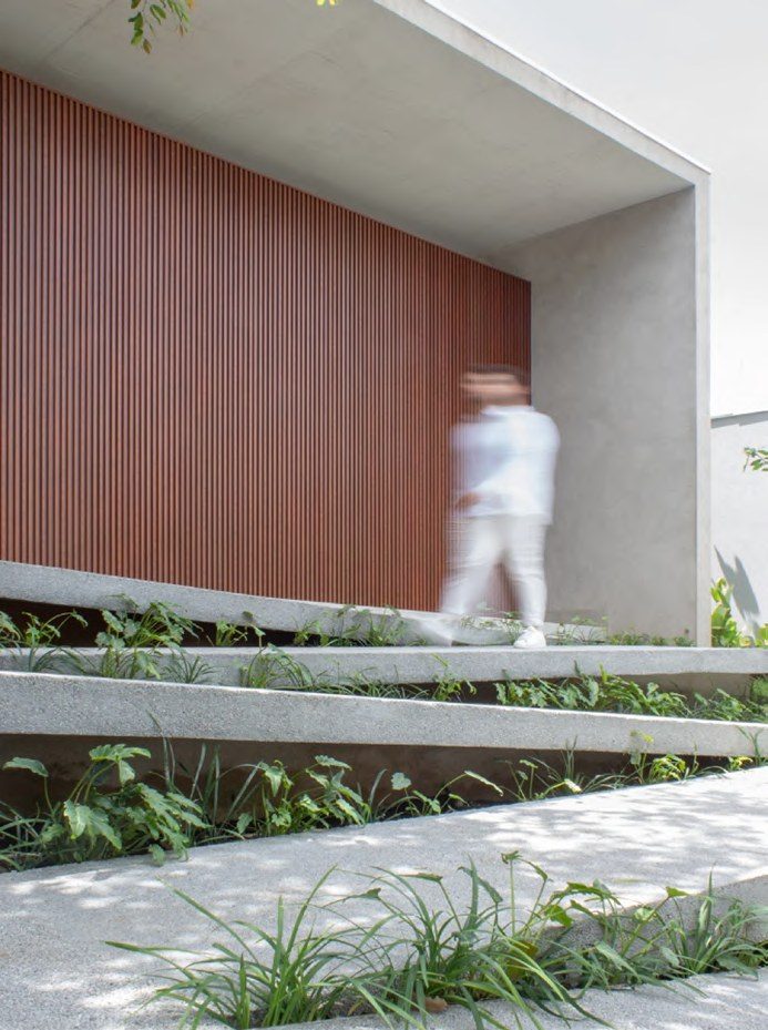 Fachada em ripas de madeira e concreto aparente, Casa Noor